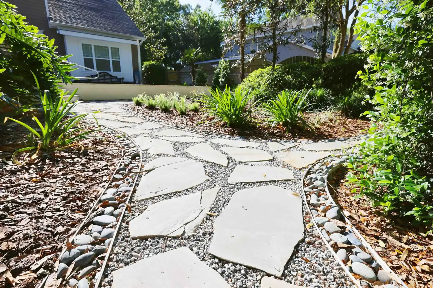 Flagstone path set in river pebbles between planted beds
