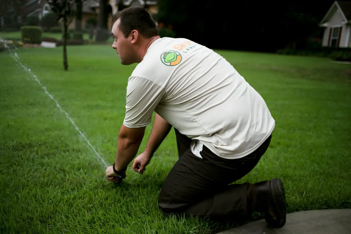 SkyFrog technician kneeling to check a sprinkler head