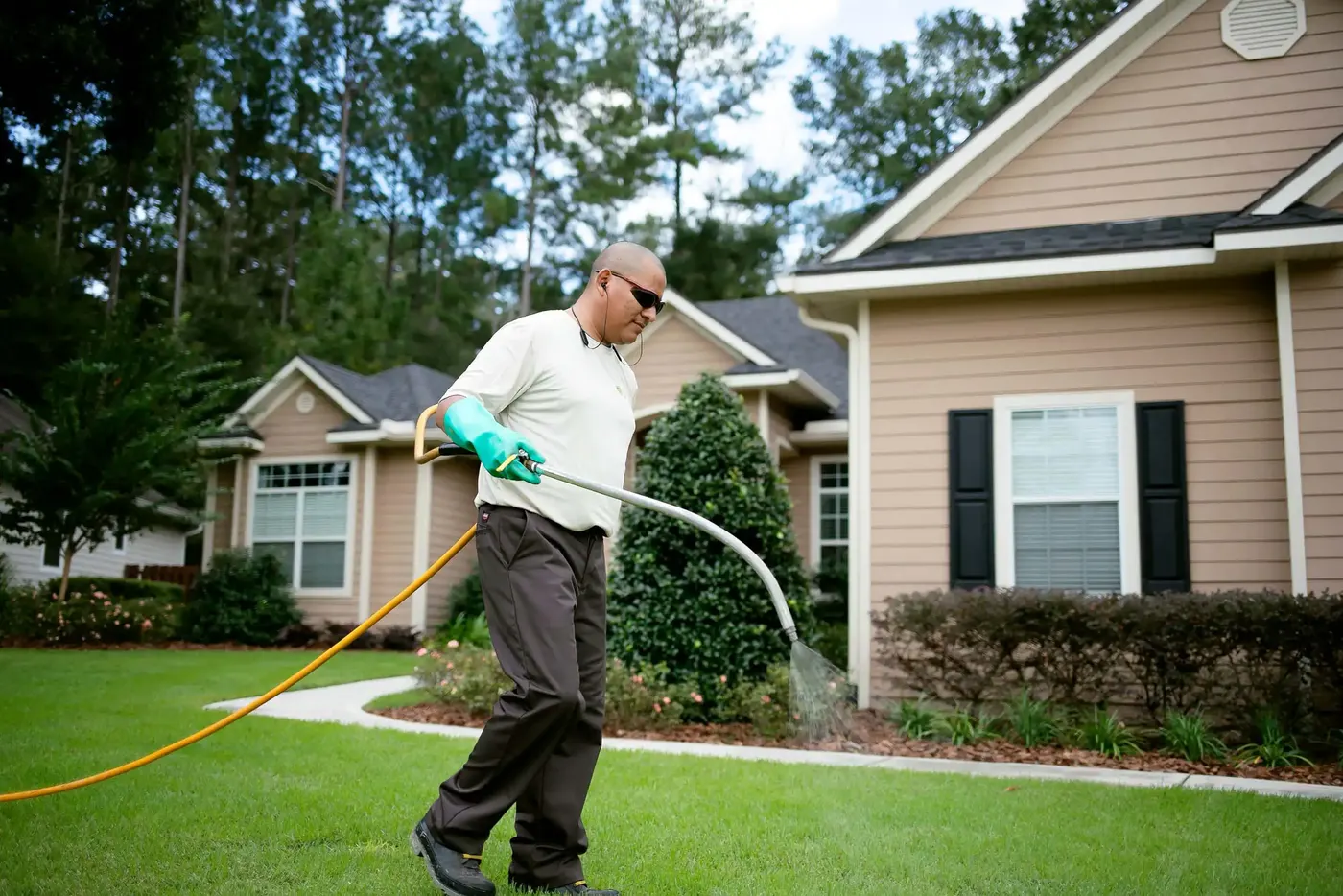 SkyFrog technician spraying a front lawn