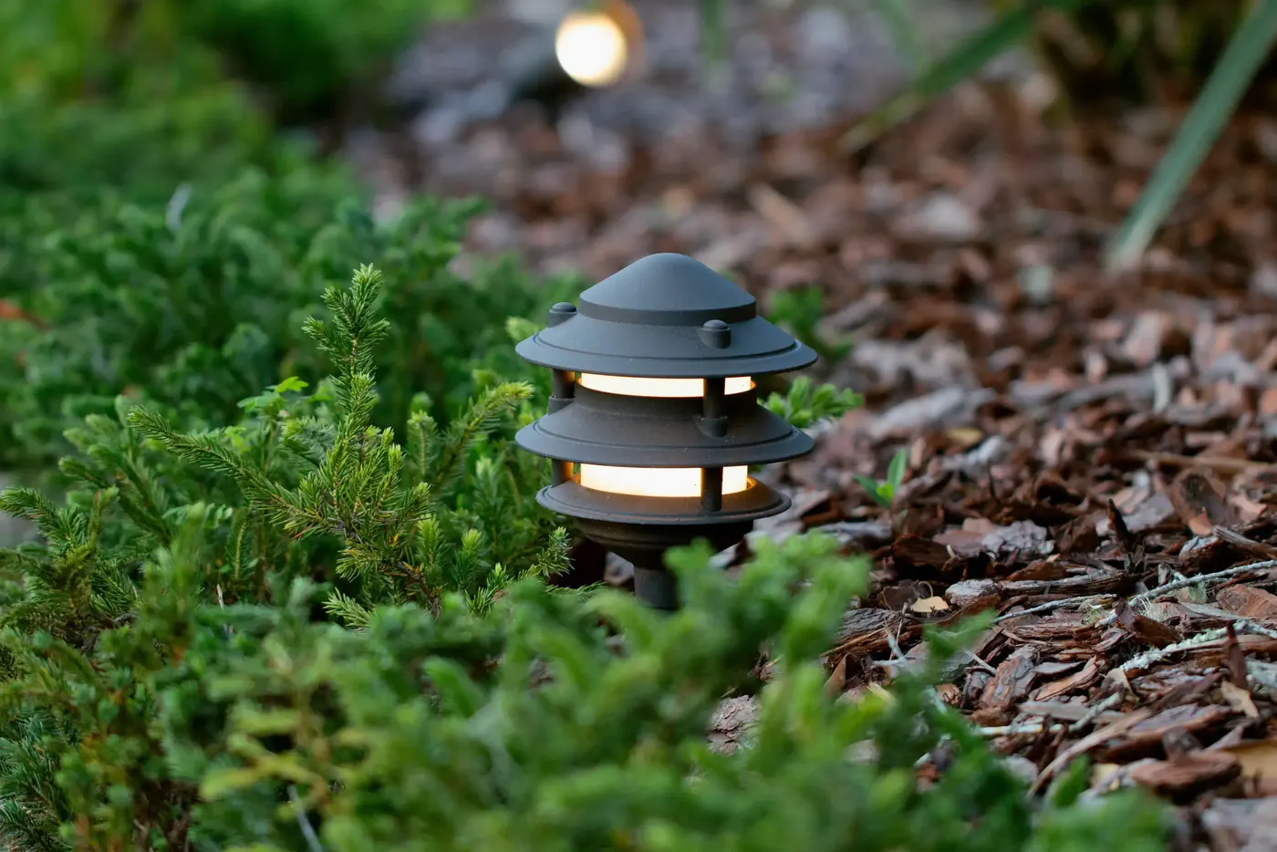 Close view of a lantern path light in a garden bed