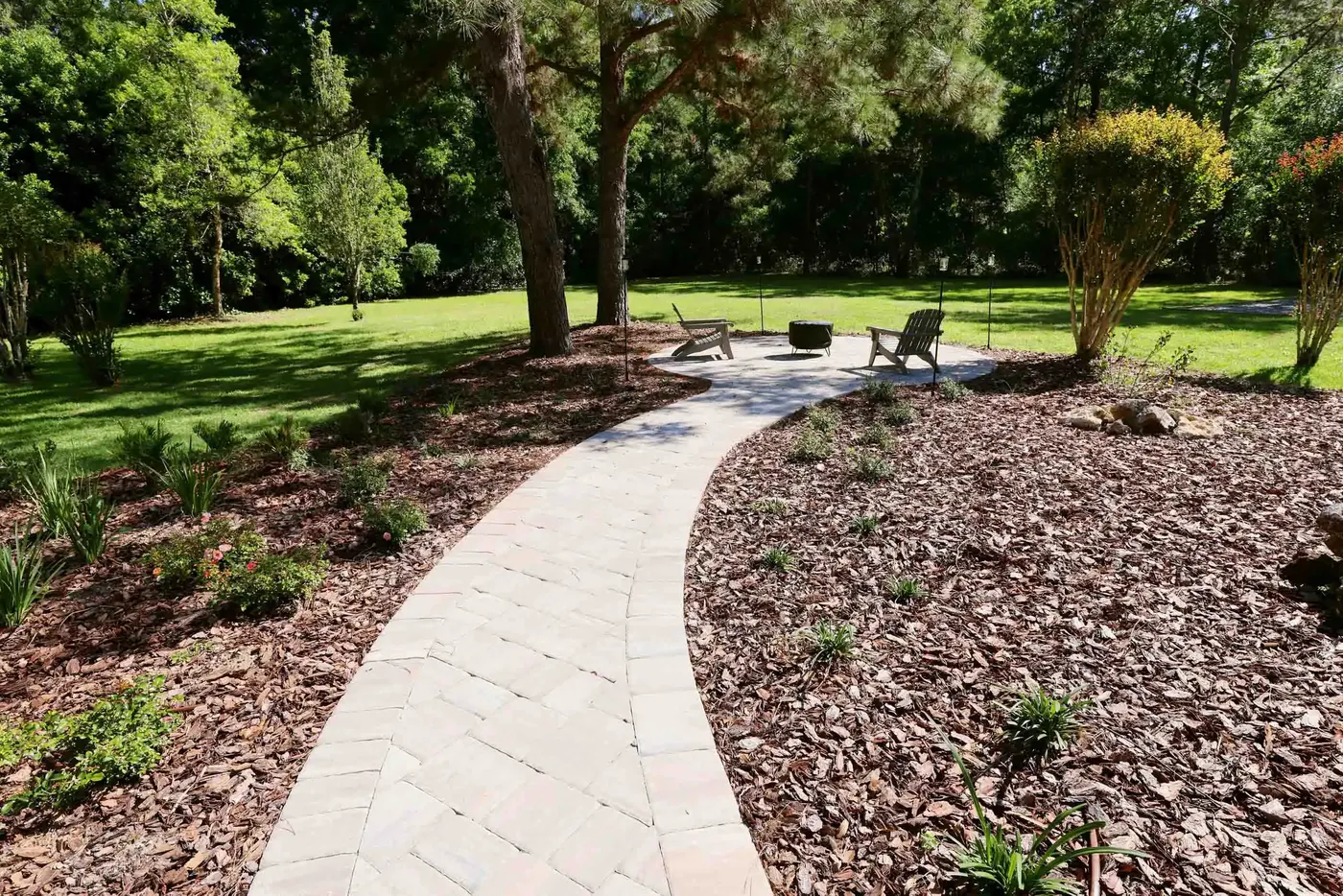 Curving paver path through mulched beds under oak trees